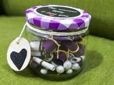 a glass jar filled with lots of different types of candy and candies on top of a green couch