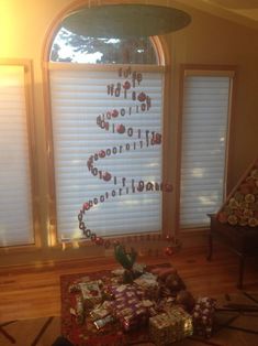 a christmas tree made out of presents in front of a window