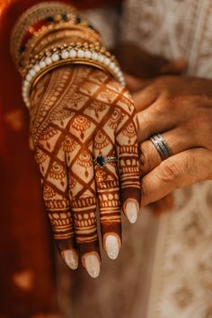 a close up of a person's hands with hennap and rings on it