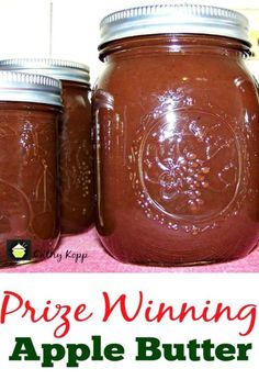 three jars filled with brown liquid and the words prize winning apple butter on top of them