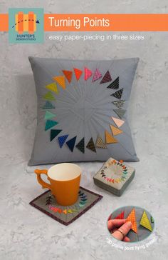 a pillow, mug and coasters are on the floor next to some crayons