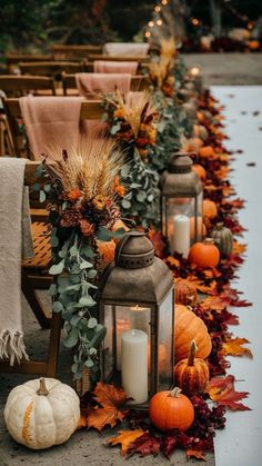 a long row of lanterns with candles and pumpkins on the ground next to each other