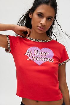 Cheeky graphic tee in a slim & cropped fit. Designed with a crew neckline & short sleeve with leopard print ringer detailing. Topped with a ‘In Your Dreams’ heart graphic across the front. Only at Urban Outfitters. Features In Your Dreams leopard graphic ringer tee Graphic baby tee -Soft & stretchy knit Crew neckline and short sleeves with leopard ringer trim ‘In your dreams’ heart graphic at the chest Slim fit Cropped length Easy pull-over style UO exclusive Content + Care 100% Cotton Machine w Cheap Urban Outfitters Graphic Print T-shirt, Cheap Urban Outfitters Graphic Print Tops, Gap Short Sleeve T-shirt With Character Print, Leopard Graphic, Applique Tee, Graphic Baby Tee, Women's Graphic Tees, Baby Graphic Tees, Heart Graphic