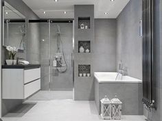 a modern bathroom with grey walls and flooring, including a walk - in shower