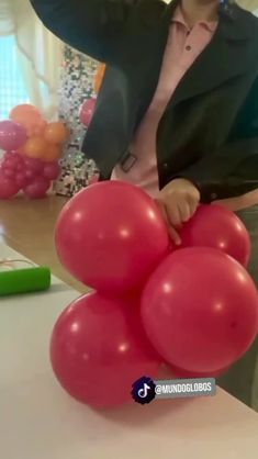 a woman is holding balloons in front of her face