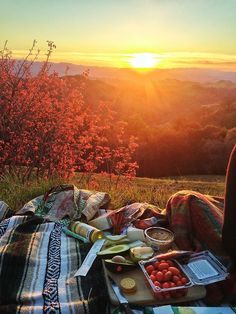 a person sitting on top of a blanket with food