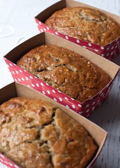 three freshly baked muffins in red and white boxes