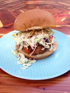 a chicken burger with coleslaw on a blue plate