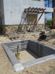 an empty pool in the sand near a building