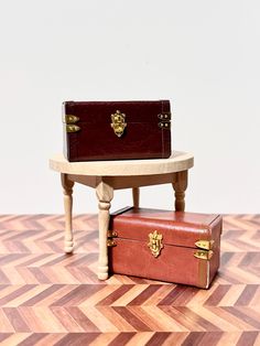 two pieces of luggage sitting on top of a wooden table