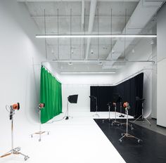 an empty studio with green curtains and lighting equipment