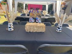 two vases with wheat stalks and photos on them are sitting on top of a table