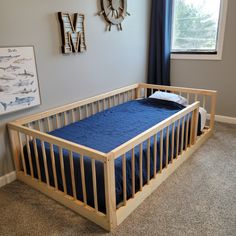 there is a small bed in the corner of this room with blue sheets on it