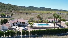 an aerial view of a house with a pool and tennis court in the foreground