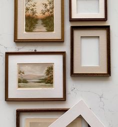 four framed pictures hang on the wall next to each other in different styles and sizes