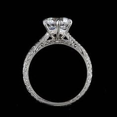 an antique style diamond engagement ring on a black background