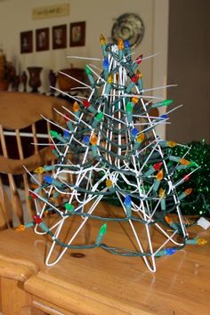 a christmas tree made out of clothes pins sitting on top of a wooden dining room table