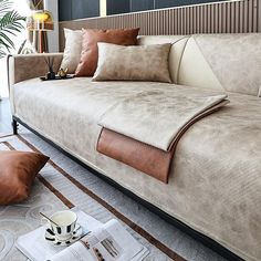 a living room with a couch, coffee cup and magazine on the floor next to it