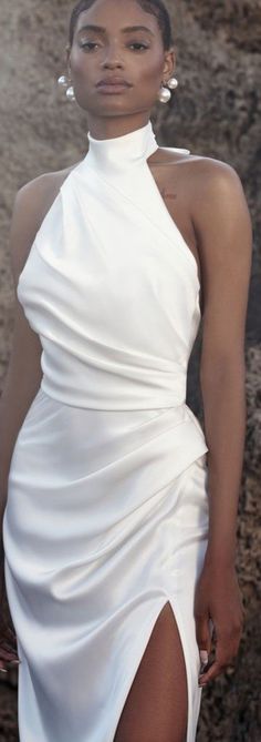 a woman in a white dress posing for the camera