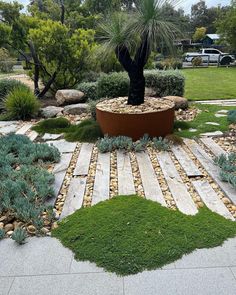 a garden with grass, rocks and plants in the center is surrounded by large stones