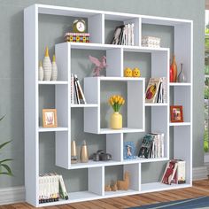 a white book shelf filled with books on top of a hard wood floor