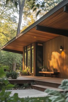 a wooden house with steps leading up to the front door and covered porch area, surrounded by greenery