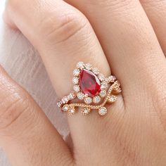 a woman's hand with a ring on it and a red stone in the middle