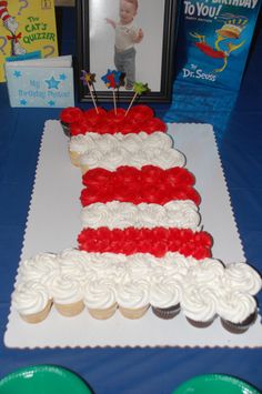 a cake that is on a table with cupcakes in the shape of an american flag