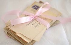 several envelopes with pink ribbon tied around them