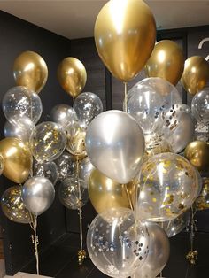 a bunch of balloons that are in the shape of gold, silver and white confetti