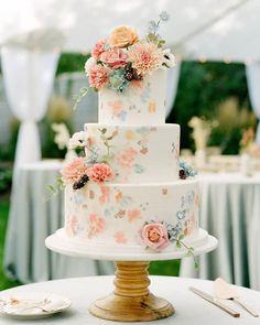 a three tiered wedding cake with flowers on the top is displayed in an instagram