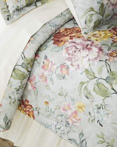 the comforter is made up with floral print and ruffles on it, along with two pillows