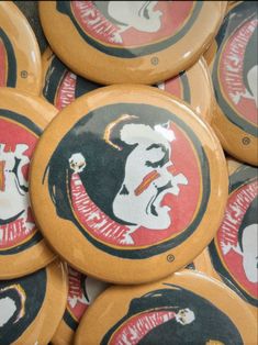 a pile of buttons with the image of a man's face on them in red, white and yellow