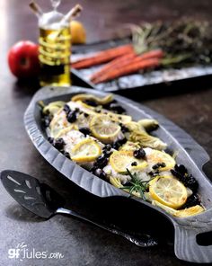 a platter filled with lemons, olives and other food on top of a table