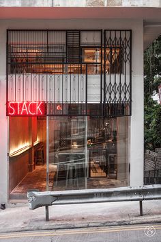 an empty bench sitting in front of a store window with the word stack on it