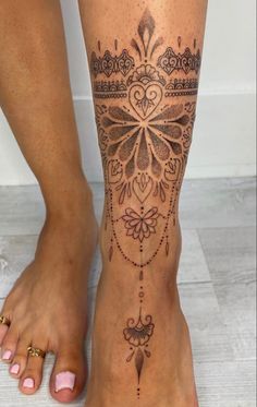 a woman's foot with tattoos on it and an intricate design in the middle