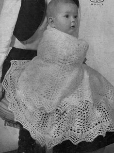 an old photo of a baby in a crochet dress