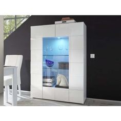 a modern white cabinet with glass doors in a dining room area next to a table and chairs