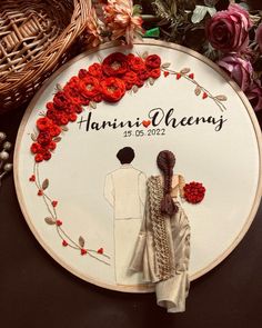 a couple is standing next to each other in front of a floral circle with the name hani and phaeng on it