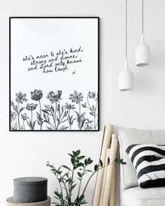 a living room with white walls and black and white artwork hanging on the wall above it