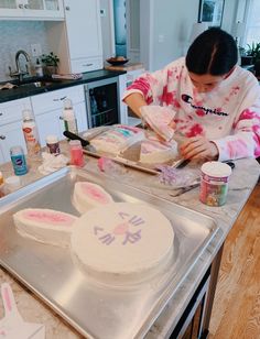 a woman decorating a cake in the kitchen with bunny ears on it's sides