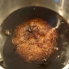 a pot filled with brown liquid sitting on top of a stove