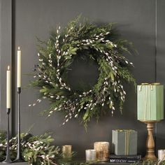 a christmas wreath and candles on a mantle