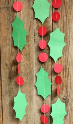 paper christmas decorations are hanging on a wooden wall with red and green poinsettis