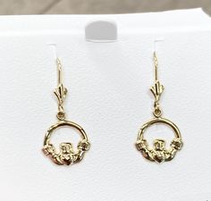 The Claddagh dangle earrings are made of 14k yellow gold. The earrings measure 11 millimeters wide and 13 millimeters long. The earrings have a Fleur De Lis lever-back. The earrings weigh 1.4 grams. We will provide a earring box. 14k Gold Drop Earrings With Bail, 14k Gold Round Lever Back Earrings, 14k Gold Lever Back Drop Earrings, Yellow Gold Lever Back Drop Earrings, Gold 14k Lever Back Jewelry, 14k Gold Dangle Earrings With Lever Back, Yellow Gold Dangle Earrings With Lever Back, Yellow Gold Lever Back Earrings For Anniversary, 14k Gold Lever Back Earrings