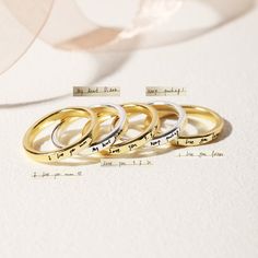 four gold wedding rings with names on them