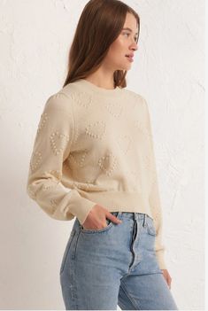 a woman is wearing a sweater and jeans