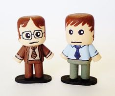 two small figurines of the same person with glasses and tie, standing next to each other