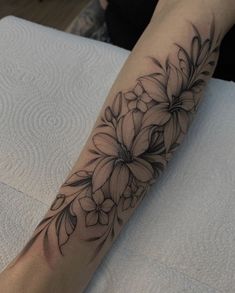 a black and white flower tattoo on the arm