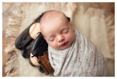 a newborn baby wrapped in a blanket with black shoes on it's feet and head